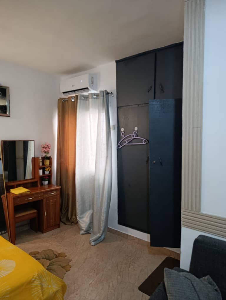 Chambre confortable de cet appartement meublé avec un placard et miroir
